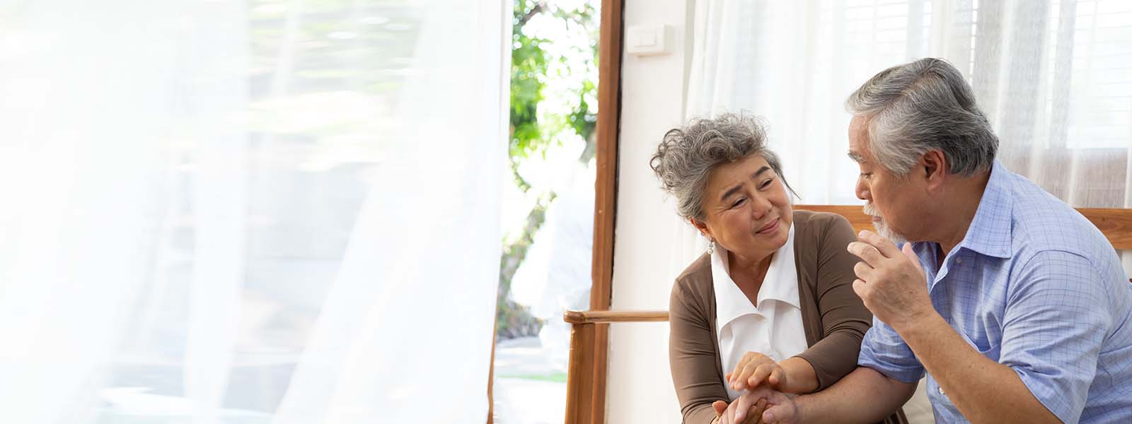 Asian senior retired couple holding hands and take care together at home